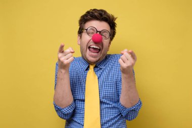 Gülen genç adam, kamerayı işaret eden bir palyaço gibi giyinmiş..