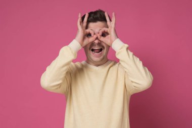 Genç adam parmaklarından bakarak iyi bir jest yapıyor..