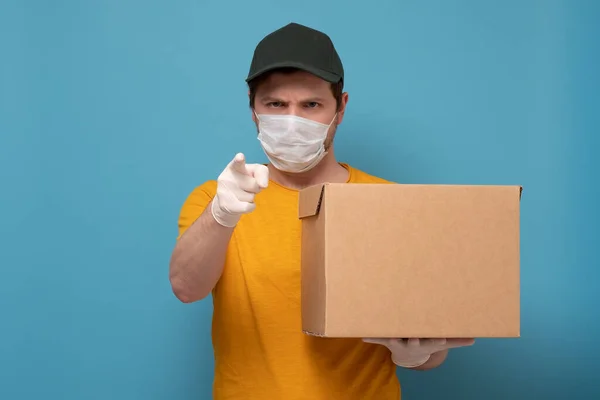 Entrega hombre sosteniendo caja de cartón en guantes de goma médica y máscara —  Fotos de Stock