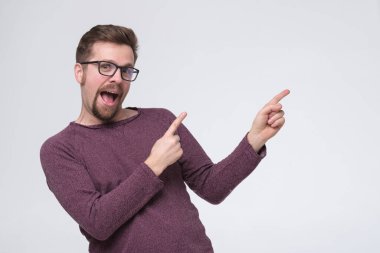 Kafkasyalı gözlüklü, iki parmağıyla işaret eden adam.