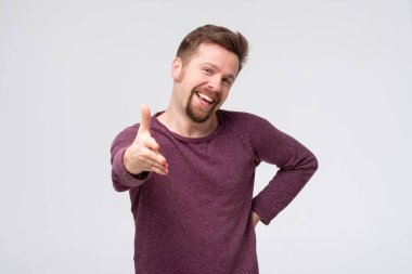 Orta yaşlı bir adam dostça gülümsüyor selamlama ve hoş geldin demek için tokalaşıyor..