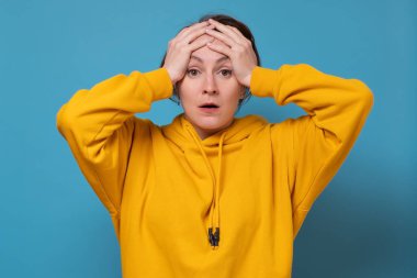 Genç bir kadın panikle el ele tutuşuyor. Önemli bir işi yapmayı unuttum..