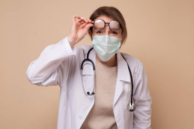 Tıbbi maskeli genç bayan doktor. Koronavirüse karşı koruma.