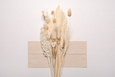 Zarfla birlikte kurumuş kır çiçekleri. Tasarımda yankı biçimi.