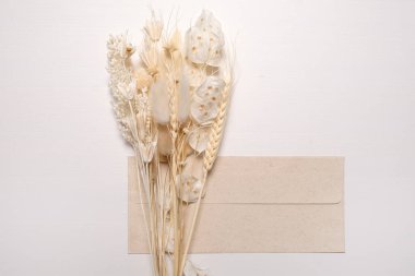 Zarfla birlikte kurumuş kır çiçekleri. Tasarımda yankı biçimi.