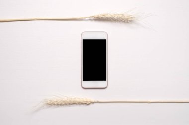 Kurumuş beyaz çiçekli siyah ekranlı telefon