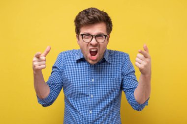 Gözlüklü beyaz adam bağırıyor ve bağırıyor..