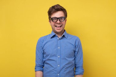 Mavi gömlekli bir adam birkaç bardak içinde gülümsüyor..