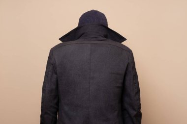 Suçlu gibi giyinmiş adama arka bakış.