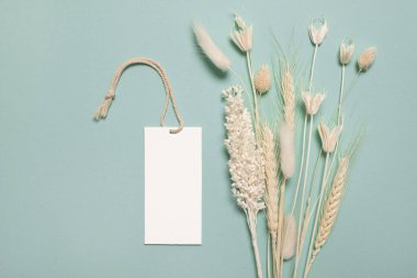 Mavi arkaplanda telif alanı etiketli çeşitli sarı kurumuş kır çiçekleri.