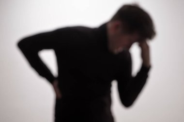 Sırtı ağrıyan bir gencin bulanık fotoğrafı. Stüdyo çekimi