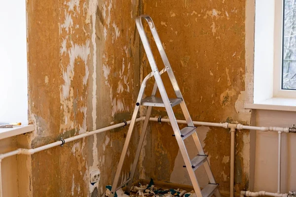 Renoverar ett rum. Tomma väggar med trappstege — Stockfoto