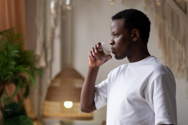 Spor eğitiminden sonra evinde bir bardak suyla Afrikalı sporcu.