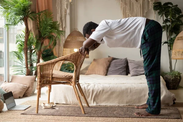 Joven africano haciendo ejercicio, practicando yoga, de pie en Ardha Uttanasana — Foto de Stock