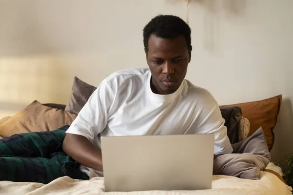 Африканський чоловік користується Інтернетом у себе вдома. — стокове фото