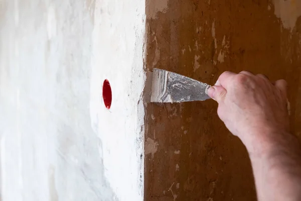 Naprawa ściany - Człowiek nakładający drzazgę na dziurę w ścianie — Zdjęcie stockowe