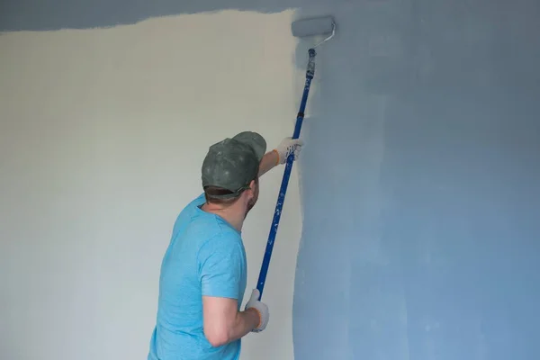 Paredes de pintura do trabalhador com um rolo durante a renovação plana — Fotografia de Stock