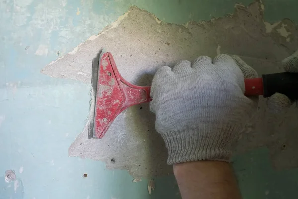 Caucasian man removing old paint with scraper tool. Stock Picture