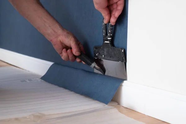 Homem cortando papel de parede. Reparação de manutenção obras de renovação no apartamento. — Fotografia de Stock