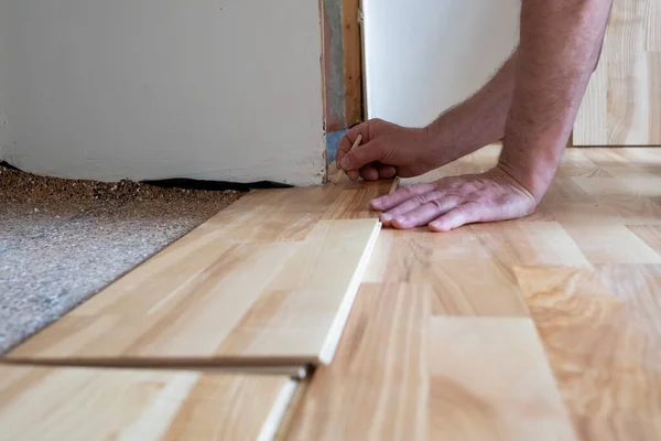 Homem caucasiano instalar placa de parquet de madeira durante o trabalho de piso — Fotografia de Stock