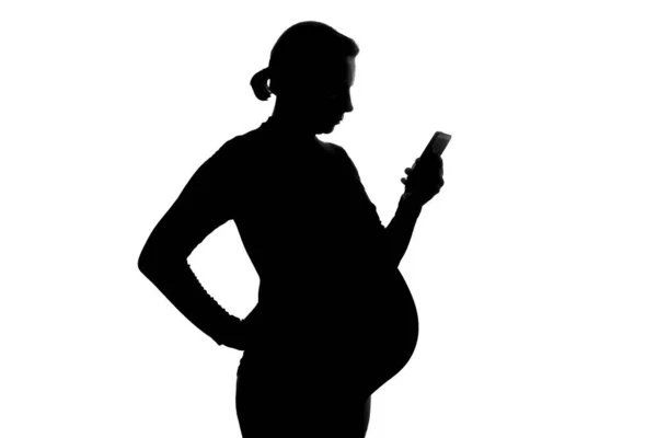 Young pregnant woman holding cell phone in her hand — Stock Photo, Image