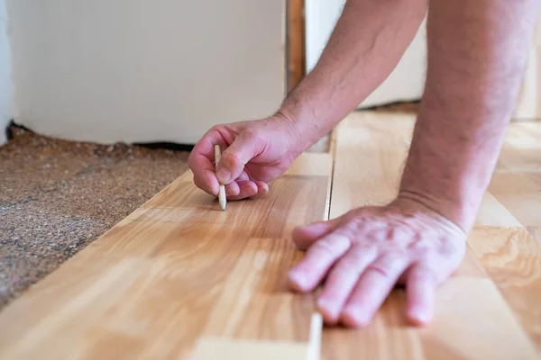 Homem caucasiano instalar placa de parquet de madeira durante o trabalho de piso — Fotografia de Stock