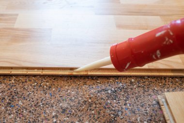 Döşemeyi yerleştirmeden önce parke için dolgu macunu uygulanıyor