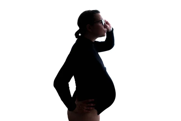 Pregnant woman expecting baby gazing through glasses on important information — Stockfoto