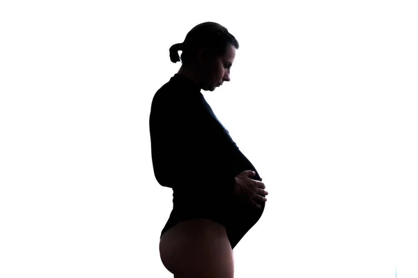 Беременная белая женщина трогает живот. В ожидании ребенка — стоковое фото