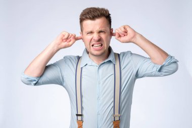 Kulağında kulağı olan ve ifadesini dinlemeyen beyaz bir genç.