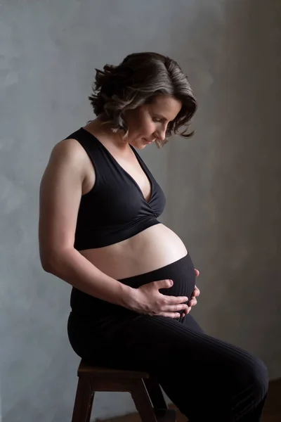 Mulher branca grávida posando em estúdio durante a sessão fotográfica. — Fotografia de Stock