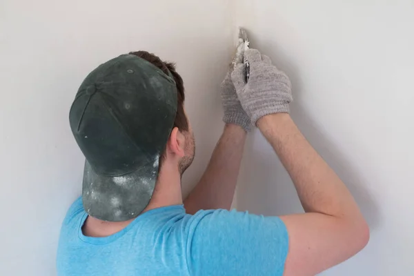 Homem sênior com faca de vidraceiro reboco reparação parede — Fotografia de Stock