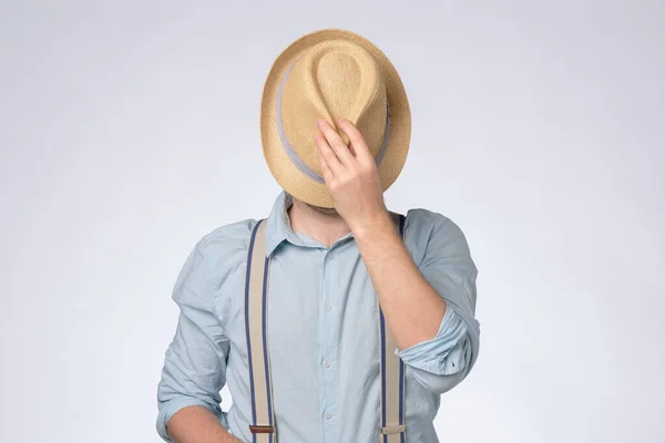 Jongeman in blauw shirt bedekt zijn ogen met zomerhoed — Stockfoto