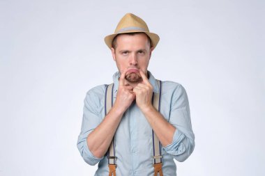 Endişeli beyaz adamın üzgün bir gülümsemesi var..