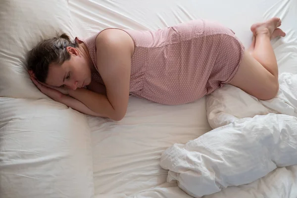 Занепокоєна вагітна жінка в ліжку страждає від безсоння — стокове фото