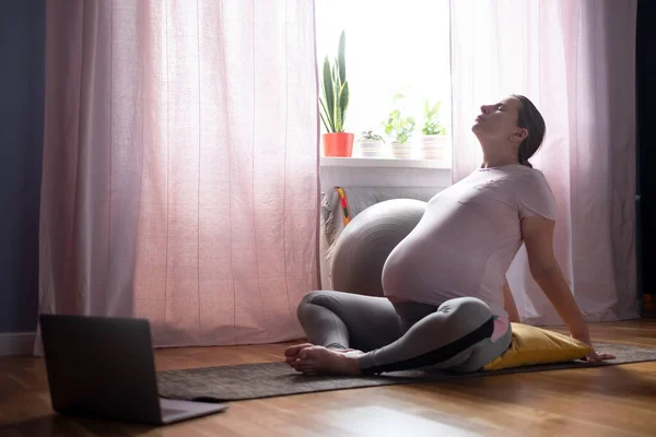 Pregnant woman exercising indoors, doing yoga asana for open chest and shoulders — Stock Photo, Image