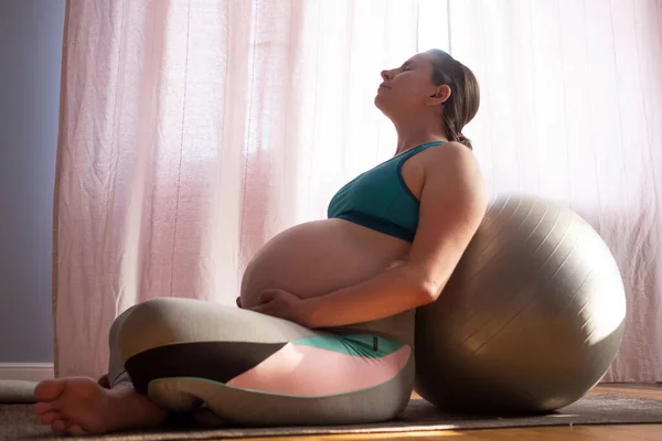 Mulher grávida se exercitando dentro de casa, fazendo ioga asana para peito aberto e ombros — Fotografia de Stock