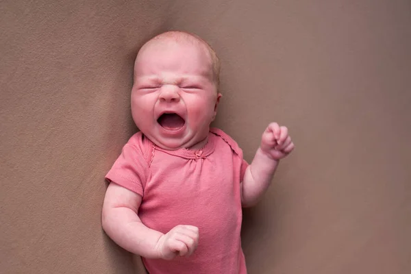 Pequeno bebê recém-nascido chorando em um cobertor marrom — Fotografia de Stock