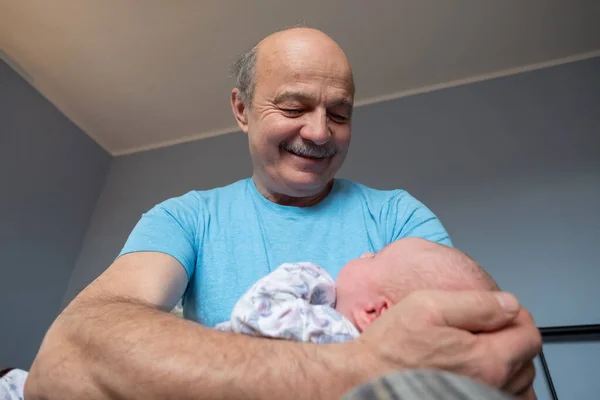 Grandfather holding a beautiful newborn baby girl — Stock Photo, Image