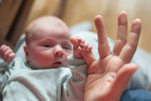 Baby girl holding mother finger. Grasping reflex of newborn — Stock Photo, Image