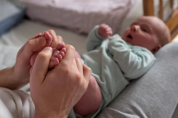 Hands holding baby feet checking reflex of a newborn. — Stock Photo, Image