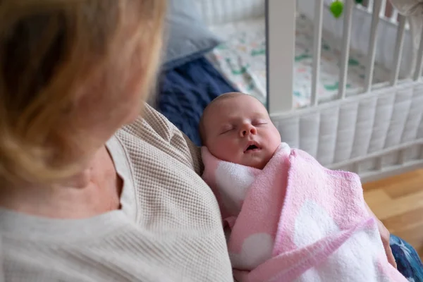 Donna anziana nonna che tiene un neonato tra le braccia — Foto Stock