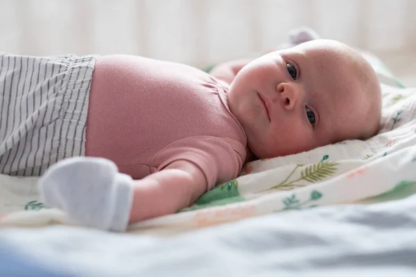 Baby dívka s palčáky chrání ji od nuly při pohledu na kameru — Stock fotografie