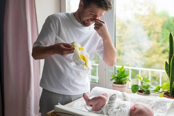 Caucasian father taking care of his newborn daughter or son changing diaper — Stock Photo, Image
