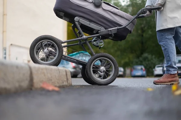 Matka popycha wózek dziecięcy przy przejściu dla pieszych — Zdjęcie stockowe