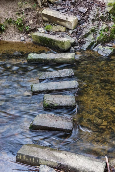 Ponte de pedra através do fluxo de água limpa — Fotografia de Stock