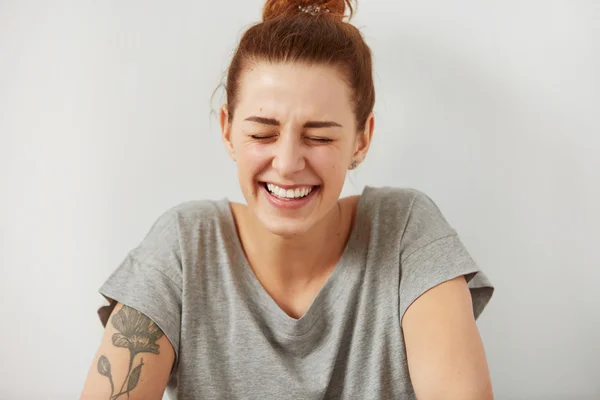 Happy woman Laughing. Closeup portrait woman smiling with perfect smile and white teeth looking laugh loudly isolated grey wall background. Positive human emotion facial expression body language.