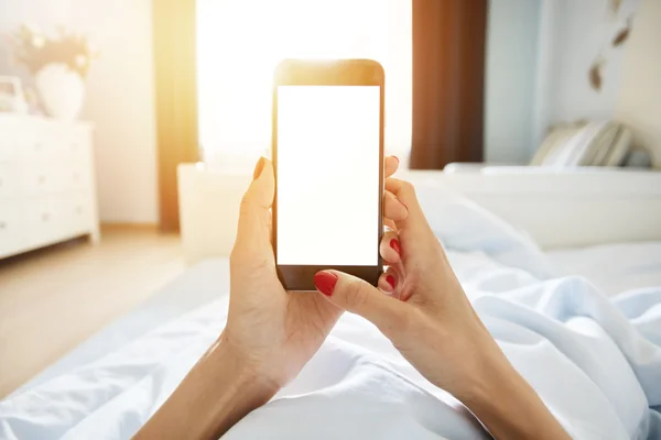 Woman using smart phone in bed