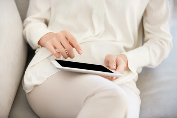Cropped image of attractive young woman wearing trendy clothes using digital tablet for online dating. Female office worker communicating with friends via social networks after hard day in the office