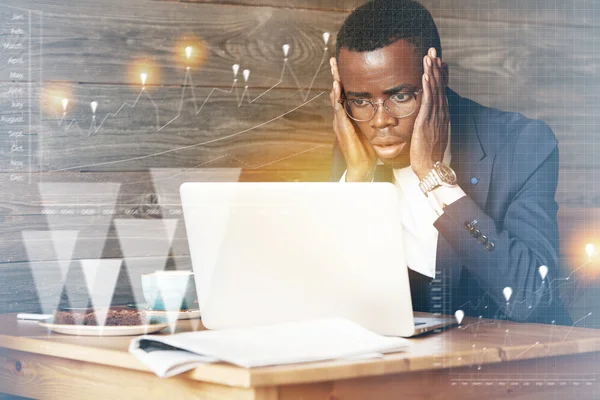 Computer problem. Double exposure of worried African corporate worker using laptop with copy space for your promotional content, looking at the screen with shocked expression, holding hands on cheeks